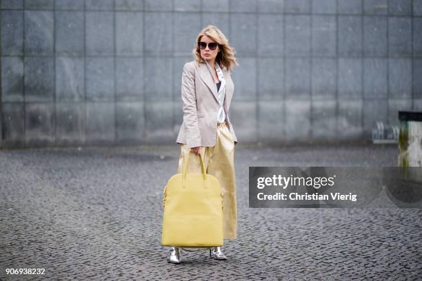 Gitta Banko wearing golden paper trousers by MM6 Martin Margiela, silver blouse from H&M, shiny beige leather blazer by Dawid Tomaszewski, taupe...