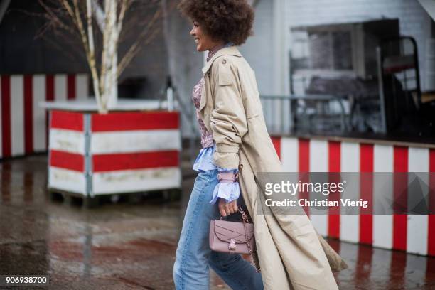 Guest wearing denim jeans, Burberry trench coat is seen outside Marina Hoermanseder during the Berlin Fashion Week January 2018 on January 18, 2018...