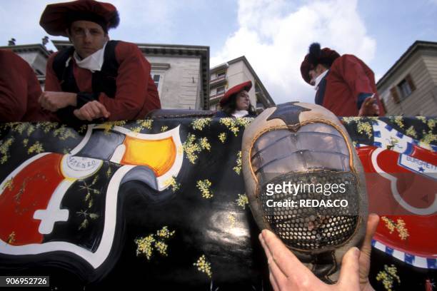 Man Gives A Protective Mask For The Battle. Traditional Carnival. Ivrea. Piemonte. Italy.