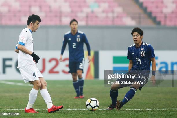 Komilov Akramjon of Uzbekistan and Takagi Akito of Japan in action during AFC U23 Championship Quarter-final between Japan and Uzbekistan at Jiangyin...