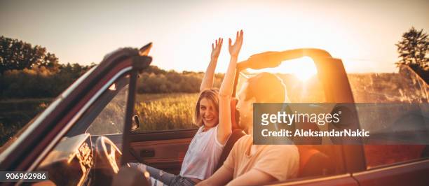 romantic moments in sunset on a road trip - couple in car smiling stock pictures, royalty-free photos & images