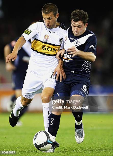 Leigh Broxham of the Victory is tackled by Vince Lia of the Phoenix during the round six A-League match between the Melbourne Victory and the...