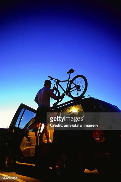 mountainbiken mann beladen fahrrad auf suv twilight himmel - halter top stock-fotos und bilder
