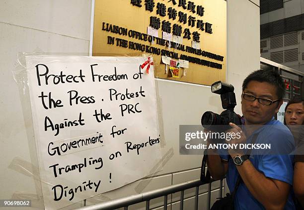 Press photographers take pictures of signs placed by journalists at the liason office of the "Central People's Government in the Hong Kong Special...