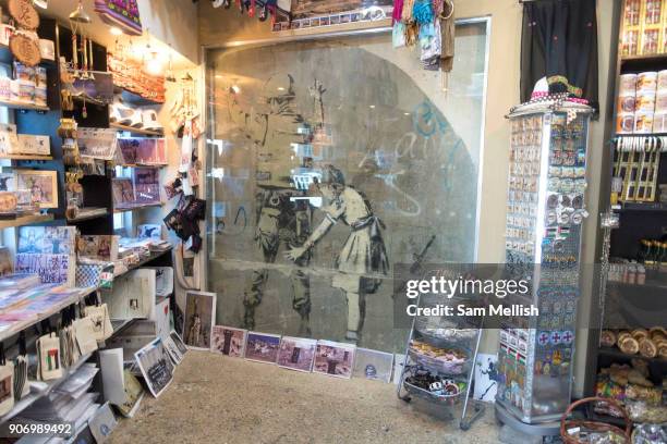 One of Banksys most iconic street art graffiti, now enclosed in a unofficial Banksy shop on 1st April 2016 in Bethlehem, West Bank. During the...