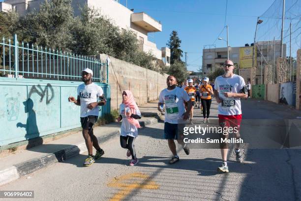 Participants running through the Al'Azza refugee camp during the Palestine Marathon on 1st April 2016 in Bethlehem, West Bank. During the Palestine...