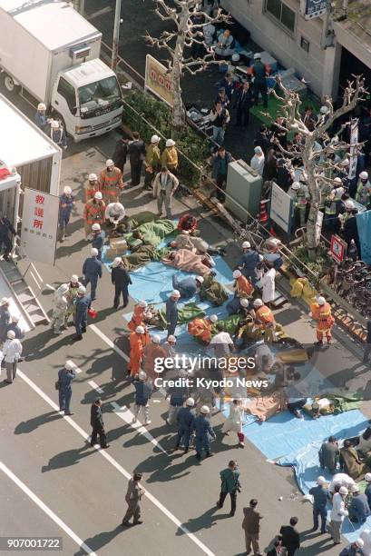 Victims are treated in front of Tsukiji Station in Tokyo after a sarin gas attack by the AUM Shinrikyo cult group hit the Tokyo subway on March 20,...