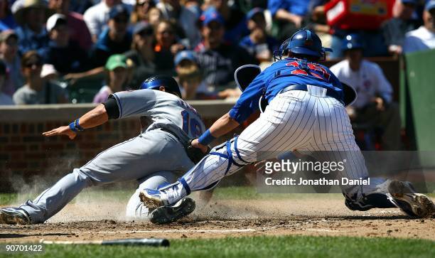Geovany Soto of the Chicago Cubs is late trying to tag Angel Pagan of the New York Mets at home plate on August 30, 2009 at Wrigley Field in Chicago,...