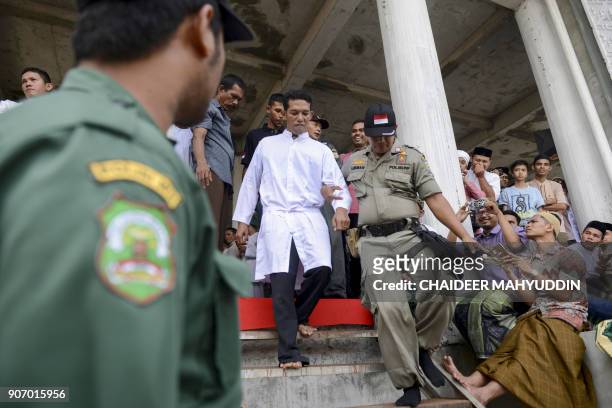 Jono Simbolon , an Indonesian Christian, is led out before being publicly flogged in front of a crowd outside a mosque in Banda Aceh, Aceh province,...