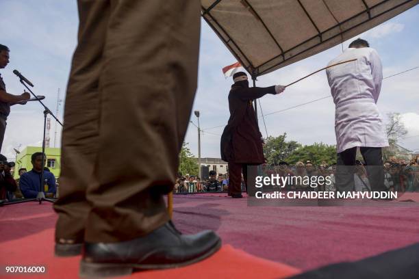 Jono Simbolon , an Indonesian Christian, is flogged in front of a crowd outside a mosque in Banda Aceh, Aceh province, on January 19, 2018. Simbolon...