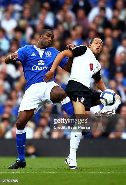 Bobby Zamora of Fulham is challenged by Sylvain Distin of Everton during the Barclays Premier League match between Fulham and Everton at Craven...