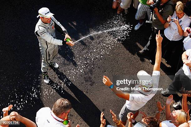 Race winner Rubens Barrichello of Brazil and Brawn GP celebrates with second placed team mate Jenson Button of Great Britain and Brawn GP in the...