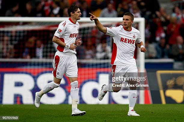 Lukas Podolski of Koeln celebrates his team's first goal with team mate Milivoje Novakovic during the Bundesliga match between 1. FC Koeln and FC...