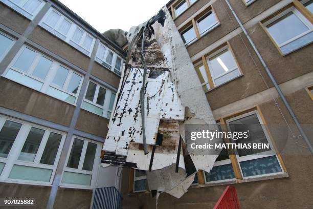 Parts of the roof structure of a primary school hang over the facade on January 19, 2018 in Halberstadt, eastern Germany, one day after the region...