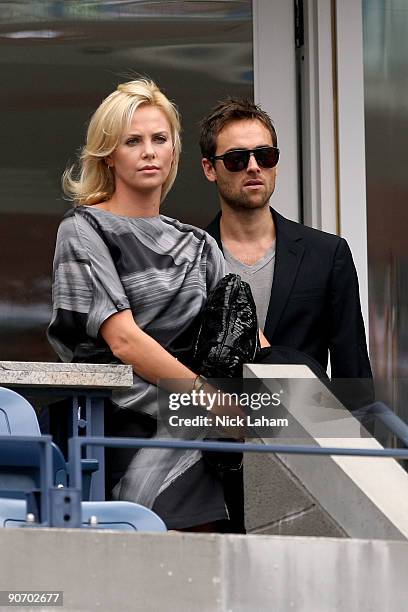 Actress Charlize Theron with actor Stuart Townsend watch the match between Rafael Nadal of Spain and Juan Martin Del Potro of Argentina during day...