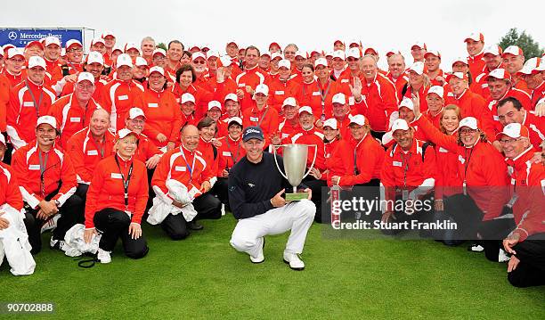 James Kingston of South Africa with the volunteers as he holds the winners trophy after winning the playoff against Ander Hansen of Denmark during...