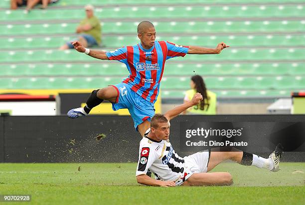 Takayuki Morimoto of Catania Calcio competes with Andrea Coda of Udinese Calcio during the Serie A match between Udinese Calacio and Catania Calcio...