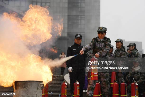 Freshman students of Hangzhou Normal University put out fire with fire extinguisher during their two-week winter military training on January 19,...