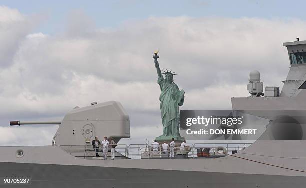 Passengers and sailors stand aboard the Dutch Naval Frigate HNMLS Tromp as it sails past the Statue of Liberty on September 13, 2009 in New York...