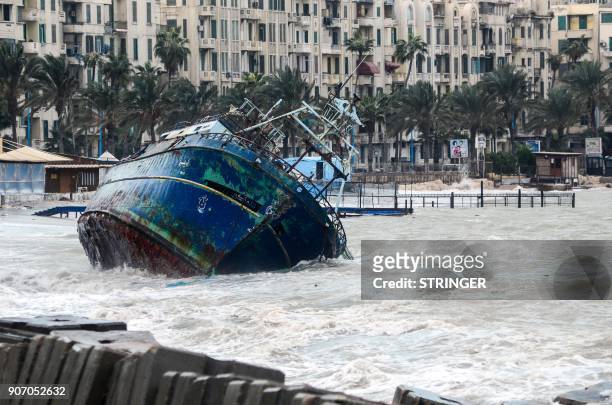 Picture taken on January 19, 2018 shows waves breaking against the hull of a ship on the shore of the Egyptian port city of Alexandria during the...