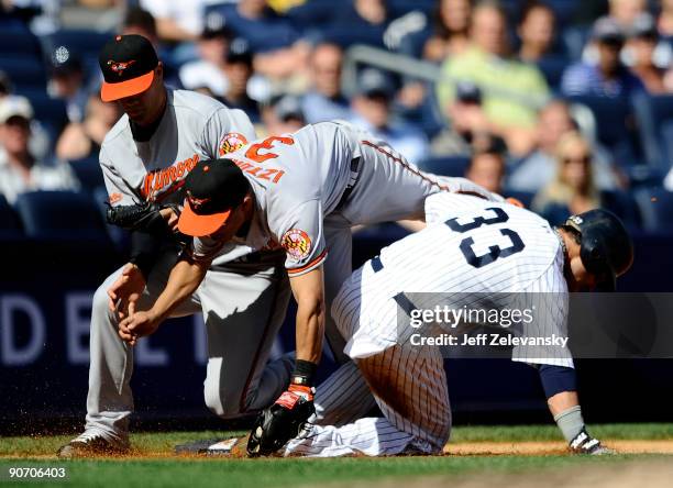 Nick Swisher of the New York Yankees collides with Cesar Izturis as Jeremy Guthrie of the Baltimore Orioles backs him up in the fourth inning of a...