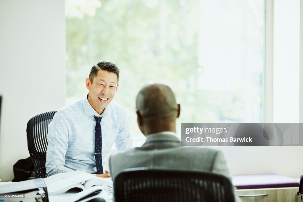 Smiling businessman in discussion with client in office