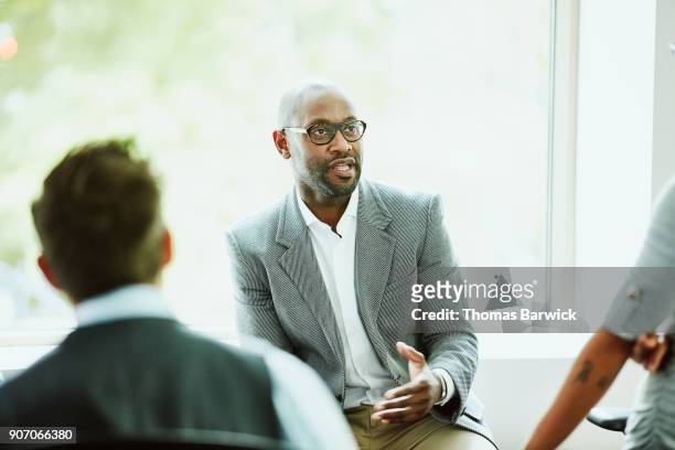 businessman leading team during informal team meeting in office - selective focus foto e immagini stock