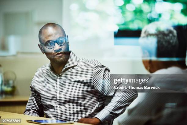 businessman listening to project manager during team meeting in office conference room - smart glass stock-fotos und bilder