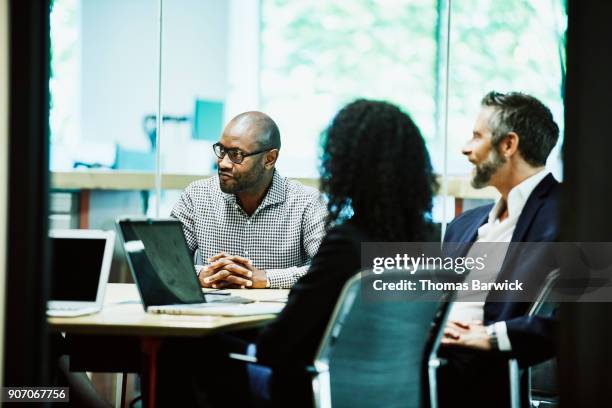 business colleagues having meeting in office conference room - better decisions stock pictures, royalty-free photos & images