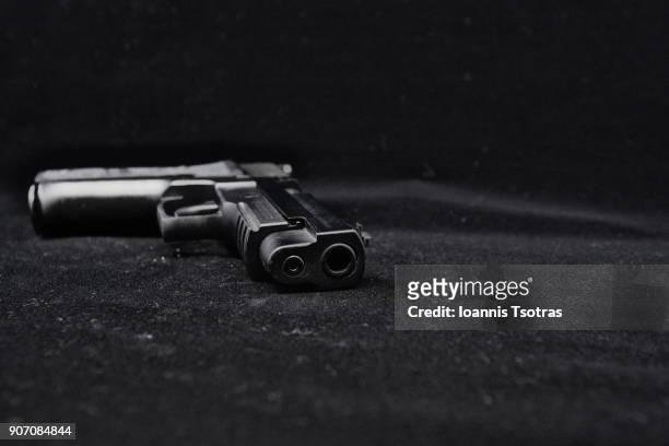 a black pistol  (gun) - killing fotografías e imágenes de stock