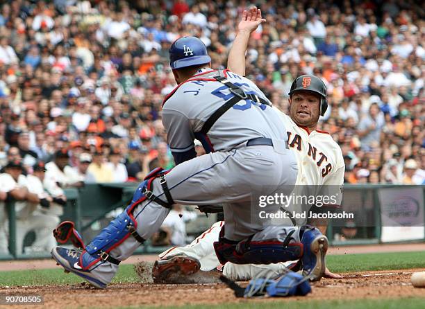Freddy Sanchez of the San Francisco Giants is tagged out at home by Russell Martin of the Los Angeles Dodgers in the sixth inning during a Major...