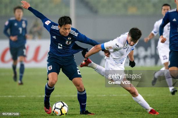 So Fujitani of Japan and Akramjon Komilov of Uzbekistan compete for the ball during the AFC U-23 Championship quarter-final match between Japan and...