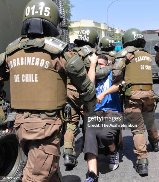 Protester participating in a rally against the visit of Pope Francis is taken by riot police officers on January 16, 2018 in Santiago, Chile.