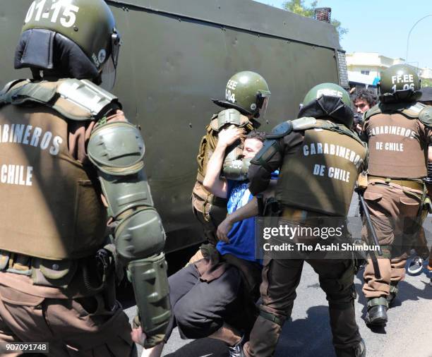 Protester participating in a rally against the visit of Pope Francis is taken by riot police officers on January 16, 2018 in Santiago, Chile.