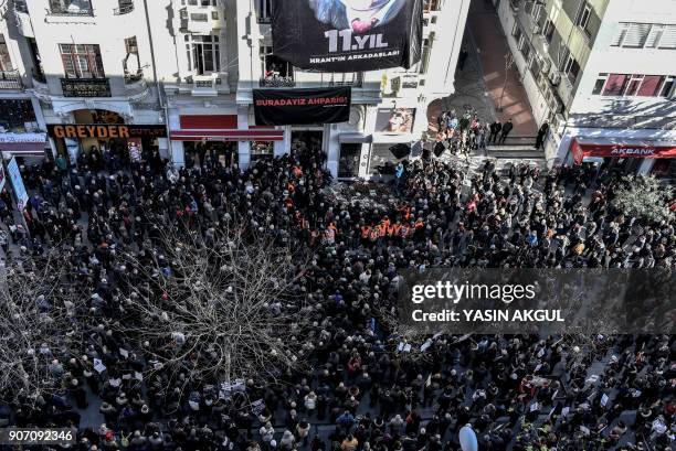 People gather in front of the offices of Armenian weekly newspaper "Agos" during a rally commemorating 11th anniversary of the assassination of...