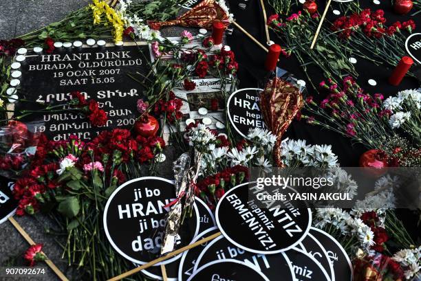 Picture taken on January 19, 2018 shows placards reading "We all are Hrant, we all are Armenians" and red carnations in front of the offices of...