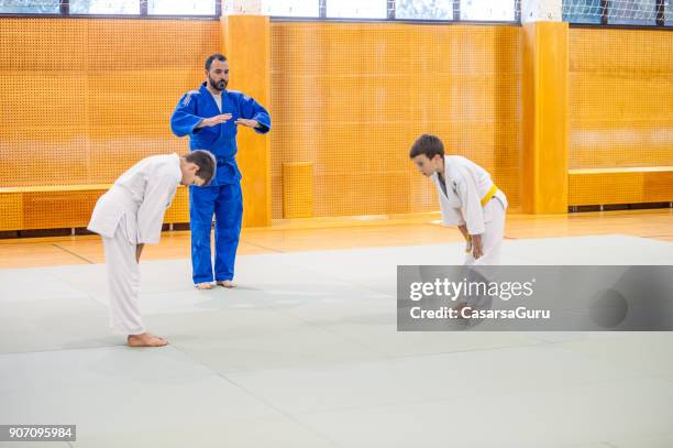 garçons sur la formation de judo - saluer en s'inclinant photos et images de collection