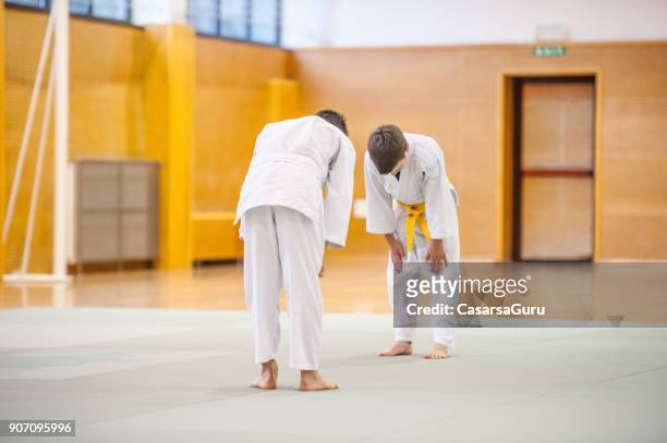 deux garçons entraînement judo lutte - saluer en s'inclinant photos et images de collection