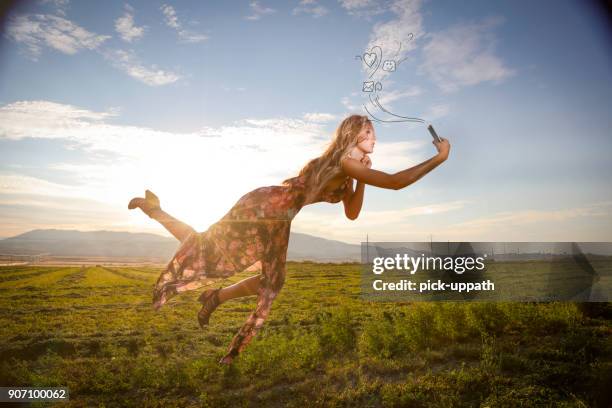 woman floating mid air with phone - angel white dress stock pictures, royalty-free photos & images
