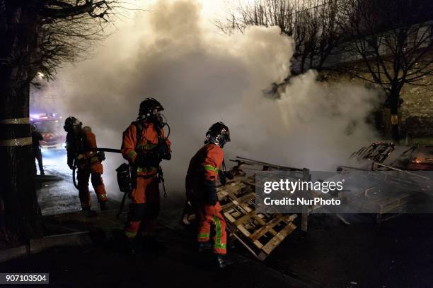 Fire Fighters try to remove a fire of wooden palettes burn as prison guards block access to Fresnes prison on January 19, 2018 to demand tighter...