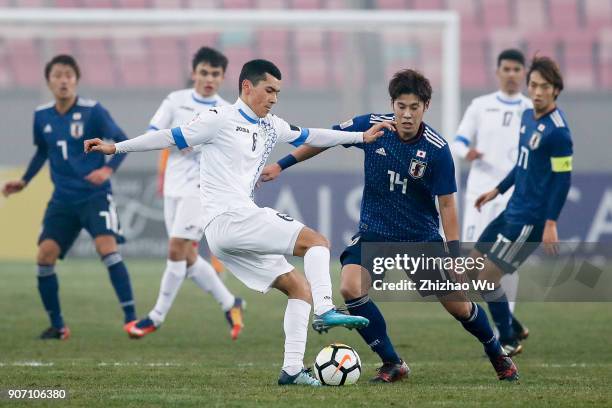 Ganiev Azizjon of Uzbekistan and Takagi Akito of Japan in action during AFC U23 Championship Quarter-final between Japan and Uzbekistan at Jiangyin...