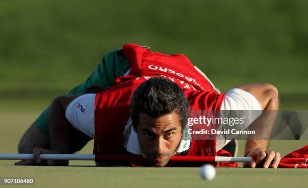 The caddy of Italian golfer Matteo Manassero known simply as 'Job' gets a worm's eye view of the line of a putt on the 16th green during the second...