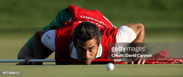 The caddy of Italian golfer Matteo Manassero known simply as 'Job' gets a worm's eye view of the line of a putt on the 16th green during the second...