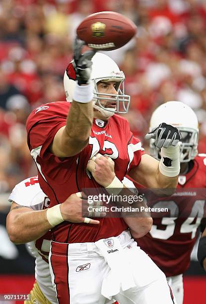 Quarterback Kurt Warner of the Arizona Cardinals throws a pass under pressure from Justin Smith of the San Francisco 49ers during the NFL game at the...