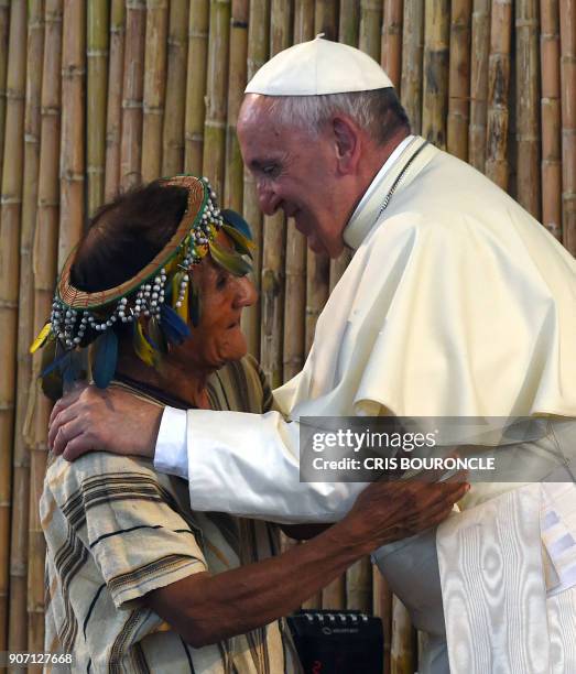 Pope Francis greets a representative of indigenous communities of the Amazon basin from Peru, Brazil and Bolivia during a meeting in the Peruvian...