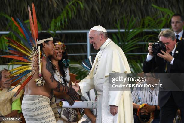 Pope Francis greets representatives of indigenous communities of the Amazon basin from Peru, Brazil and Bolivia during a meeting in the Peruvian city...