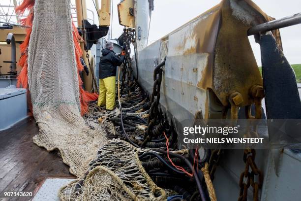 Fisherman on the Dutch fishing boat TX-38 Branding IV prepares the electric pulse fishing nets during departure from the harbour of Den Helder, on...