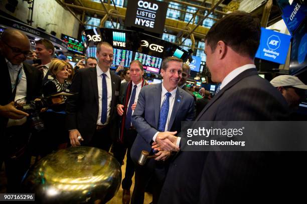 Timothy Whall, chief executive officer of ADT Inc., center right, shakes hands with Tom Farley, president of the NYSE Group Inc., left, during the...