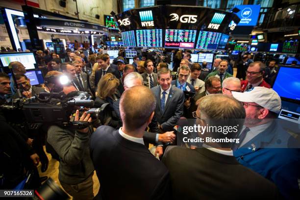 Timothy Whall, chief executive officer of ADT Inc., center, watches a trader give a television interview during the company's initial public offering...