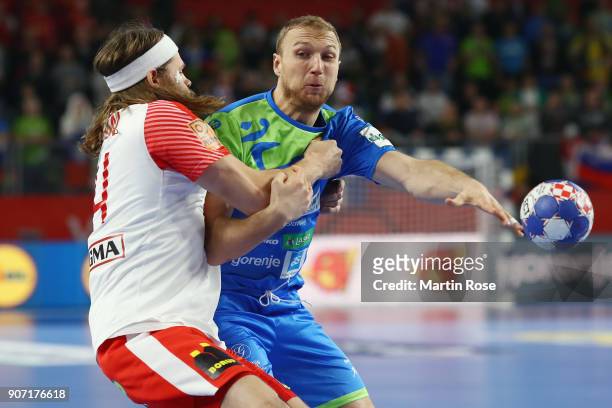 Ziga Mlakar of Slovenia is challenged by Mikkel Hansen of Denmark during the Men's Handball European Championship main round group 2 match between...